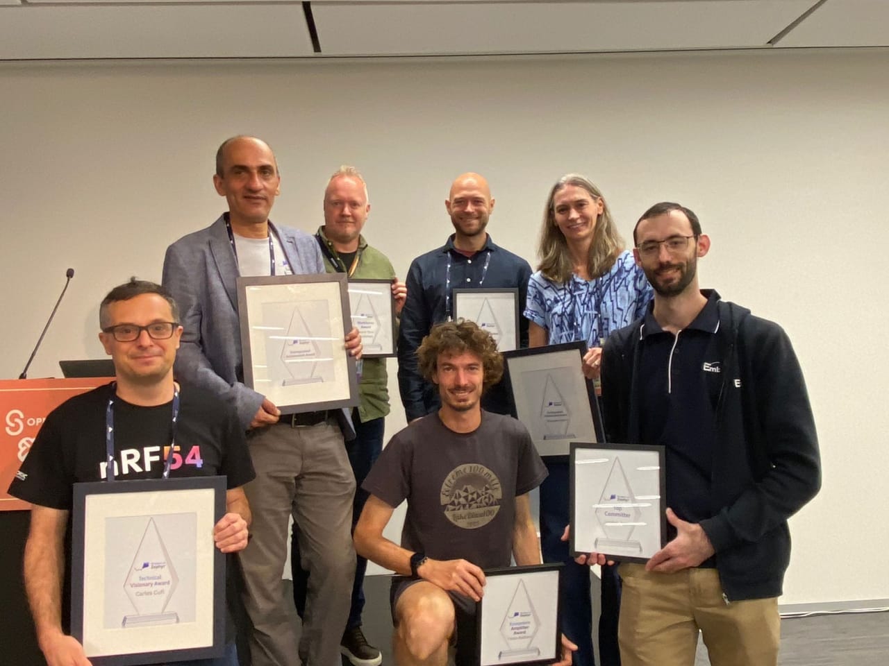 Jordan Yates with Zephyr award recipients, holding a Community Award, Prague, October 2026